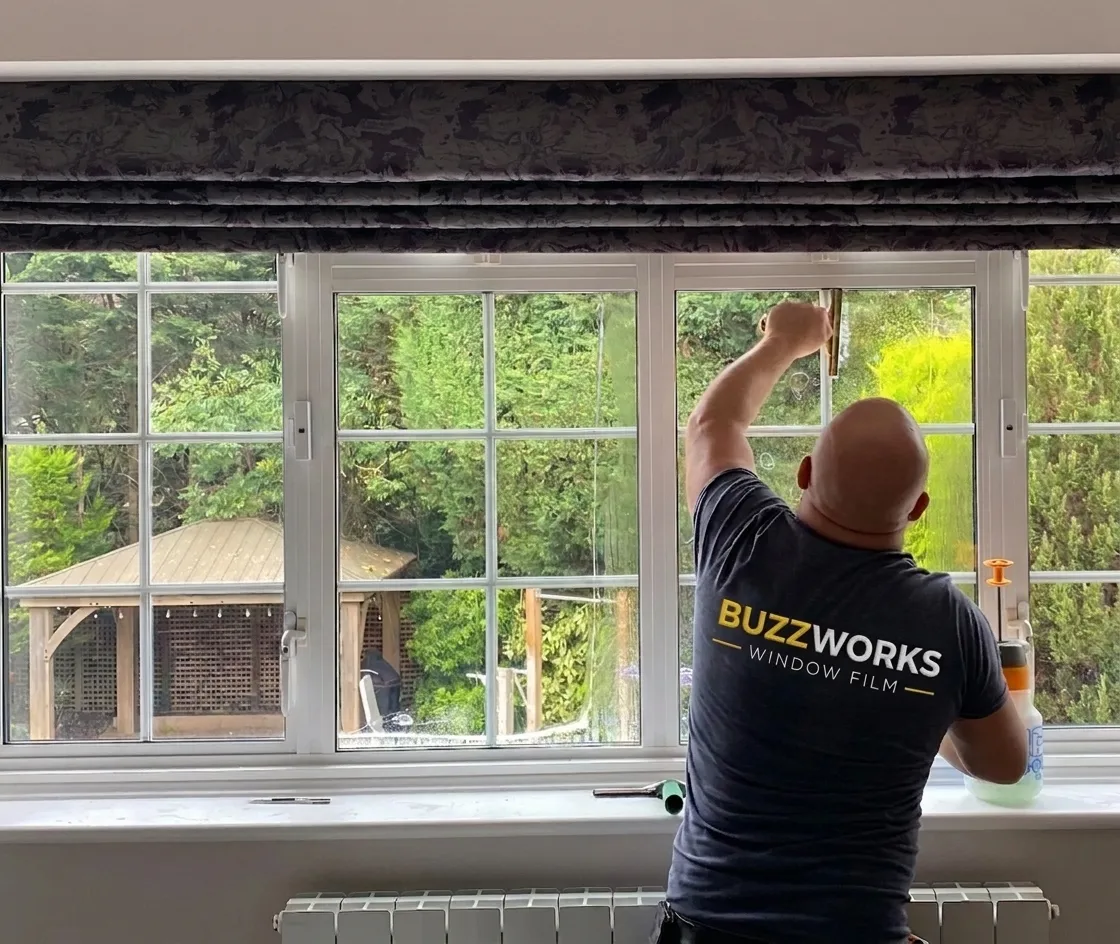 A Buzzworks fitter applying window film to a home window